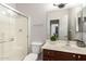 Bright bathroom features a shower with glass door, white toilet, and vanity with brown cabinets at 14244 W Indianola Ave, Goodyear, AZ 85395