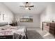 Calm bedroom with a ceiling fan, window views, and a plush rug adds to the room's comfort at 14244 W Indianola Ave, Goodyear, AZ 85395