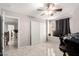 Well-lit bedroom with sliding door closet, window with dark curtains, and neutral wall paint color at 14244 W Indianola Ave, Goodyear, AZ 85395