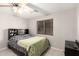 Cozy bedroom featuring a queen-sized bed with built-in headboard and storage, window, and ceiling fan at 14244 W Indianola Ave, Goodyear, AZ 85395