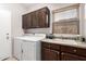 Functional laundry room with storage cabinets, a sink, and a washing machine set at 14244 W Indianola Ave, Goodyear, AZ 85395