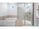Well-lit bathroom showcasing a soaking tub, glass shower enclosure, and modern fixtures at 8746 W Denton Ln, Glendale, AZ 85305