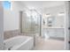 Modern bathroom with a soaking tub, glass shower, and double vanity sinks at 8746 W Denton Ln, Glendale, AZ 85305