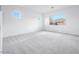 Spacious bedroom boasts soft carpet, white walls, and natural light from multiple windows at 8746 W Denton Ln, Glendale, AZ 85305