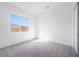 Neutral bedroom with a large window offering natural light and plush carpeting at 8746 W Denton Ln, Glendale, AZ 85305