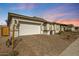 Exterior shot of a one-story home with a brick driveway and a two-car garage at 8746 W Denton Ln, Glendale, AZ 85305