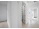 Hallway with tiled floor and neutral colored walls leading to an open bedroom with closet space at 8746 W Denton Ln, Glendale, AZ 85305