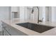 Modern kitchen sink with stainless steel faucet set in a white quartz countertop at 8746 W Denton Ln, Glendale, AZ 85305