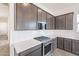 Modern kitchen with dark cabinetry, quartz countertops, and stainless steel appliances at 17993 W Long Lake Rd, Goodyear, AZ 85338