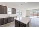 Modern kitchen with dark cabinetry, quartz countertops, and stainless steel appliances at 17993 W Long Lake Rd, Goodyear, AZ 85338