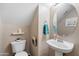 Small bathroom with white pedestal sink and decorative mirror at 15603 N 79Th N Dr, Peoria, AZ 85382