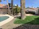 Landscaped backyard with a pool, palm trees, and a built-in grill at 7211 E Sunnyside Dr, Scottsdale, AZ 85260