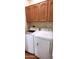 Functional laundry room with modern, white washer and dryer, and overhead cabinets at 7027 N Scottsdale Rd # 237, Scottsdale, AZ 85253