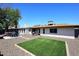 Spacious backyard featuring an artificial lawn, patio with furniture, grill, and gravel area at 1531 W Plana Ave, Mesa, AZ 85202