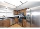 Well-lit kitchen featuring stainless steel appliances, wood cabinets, and durable countertops at 1531 W Plana Ave, Mesa, AZ 85202