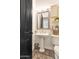 Powder room with pedestal sink, decorative mirror, and tiled flooring at 8006 S 38Th Pl, Phoenix, AZ 85042