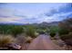 Long, private driveway leading up to a desert estate with beautiful mountain views in the distance at 7702 N Moonlight Ln, Paradise Valley, AZ 85253