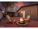 Cozy backyard featuring a red brick patio, a fire pit, two Adirondack chairs, and a charming guesthouse at 322 N 11Th Pl, Phoenix, AZ 85006