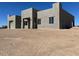 Contemporary home featuring a flat roof and simple lines, with a light stucco exterior set on a expansive, unfinished plot at 504 N 297Th Ln, Buckeye, AZ 85396