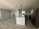 Modern kitchen featuring stainless steel appliances, a center island, and tile floors at 504 N 297Th Ln, Buckeye, AZ 85396
