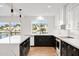 Bright modern kitchen featuring white cabinets, black cabinets and an island at 5439 S Lighthouse Ln, Tempe, AZ 85283