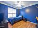 Small bedroom with blue walls, single bed, and wood flooring at 14727 N Gil Balcome N Ct, Surprise, AZ 85379