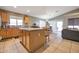 Spacious kitchen with an island, wooden cabinets, and tiled floor at 14727 N Gil Balcome N Ct, Surprise, AZ 85379