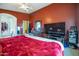 Primary bedroom with king-size bed, dark wood furniture, and a large TV at 14727 N Gil Balcome N Ct, Surprise, AZ 85379