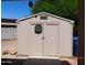 Tan colored storage shed with double doors and dartboard at 14727 N Gil Balcome N Ct, Surprise, AZ 85379