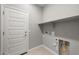 Neutral laundry room features built-in shelving, a tiled floor, and a white painted door at 2851 N Coronado Dr, Florence, AZ 85132