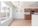 Dining space with a large window, view of kitchen with wooden cabinets and a breakfast bar at 31777 N Sundown Dr, San Tan Valley, AZ 85143