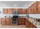 Well-appointed kitchen with granite countertops, stainless steel appliances, and wooden cabinets at 31777 N Sundown Dr, San Tan Valley, AZ 85143