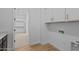 Functional laundry room with ample storage and hardwood style flooring for added appeal at 32535 N 135Th Dr, Peoria, AZ 85383