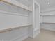 Spacious walk-in closet featuring white shelving and wooden rods for ample storage and organization at 32535 N 135Th Dr, Peoria, AZ 85383