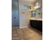 Bathroom featuring a double vanity, and walk-in shower with tile surround at 10005 W Spur Dr, Peoria, AZ 85383