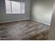 Cozy bedroom with light gray walls, a large window, and wood-look tile flooring at 10005 W Spur Dr, Peoria, AZ 85383