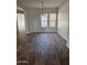 Bright dining room with two windows, modern chandelier, and wood-look tile flooring at 10005 W Spur Dr, Peoria, AZ 85383