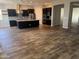 A spacious kitchen with dark cabinets, an island, stainless steel appliances, and wood-look tile flooring at 10005 W Spur Dr, Peoria, AZ 85383