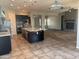 Spacious kitchen with a center island, stainless steel appliances, and a brick fireplace in the background at 10005 W Spur Dr, Peoria, AZ 85383