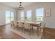 Sunlit dining area features hardwood floors, a large table with seating for ten, and modern chandelier at 1606 E Minton St, Mesa, AZ 85203