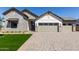Beautiful exterior elevation of a home showcasing a stone facade, multi-car garage, and manicured lawn at 1606 E Minton St, Mesa, AZ 85203
