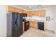 Functional kitchen featuring wood cabinets, black appliances, and durable tile flooring at 634 S Pasadena --, Mesa, AZ 85210