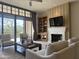 Comfortable living room with fireplace, built-in shelving, large windows, and ceiling fan at 8 E Biltmore Est # 109, Phoenix, AZ 85016