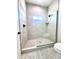 Modern bathroom with tiled walk-in shower featuring a glass door and stone flooring at 22205 W Ocupado Dr, Wittmann, AZ 85361
