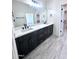 Bathroom featuring double vanity, quartz countertop, and a walk-in closet at 22205 W Ocupado Dr, Wittmann, AZ 85361