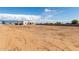 Wide angle shot of the back exterior showcasing a minimalist design and spacious yard with clear blue skies at 22205 W Ocupado Dr, Wittmann, AZ 85361