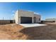 Exterior view of a modern single-Gathering home, featuring a xeriscaped front yard, spacious lot, and blue skies at 22205 W Ocupado Dr, Wittmann, AZ 85361