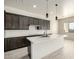 Kitchen island with white quartz countertop, pendant lights and stainless steel faucet at 22205 W Ocupado Dr, Wittmann, AZ 85361