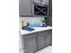 Kitchen counter with 'Gathering' sign, wine rack, and dark cabinets at 22205 W Ocupado Dr, Wittmann, AZ 85361