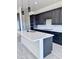 Stylish kitchen with a large island, dark cabinets, and modern lighting fixtures at 22205 W Ocupado Dr, Wittmann, AZ 85361